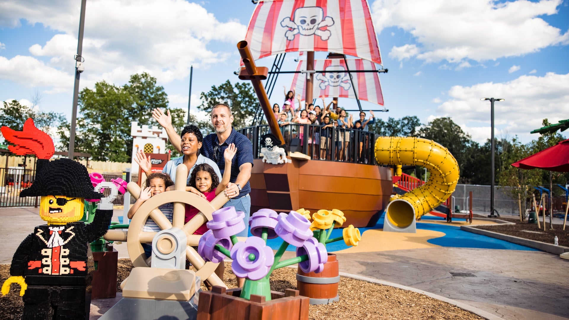 Family at the helm of a pirate ship ride at LEGOLAND New York